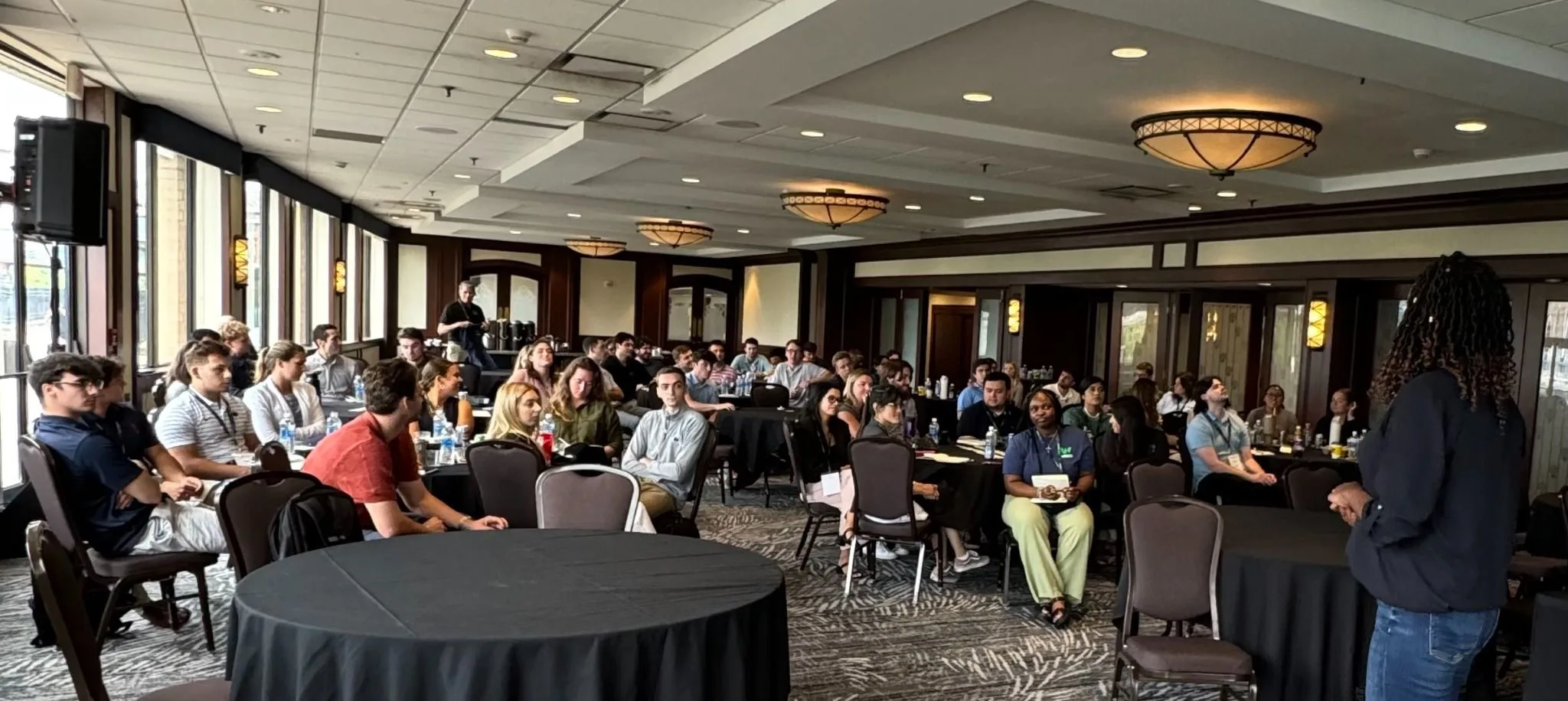 Rachel Bolton leading an engaged audience in a large meeting room
