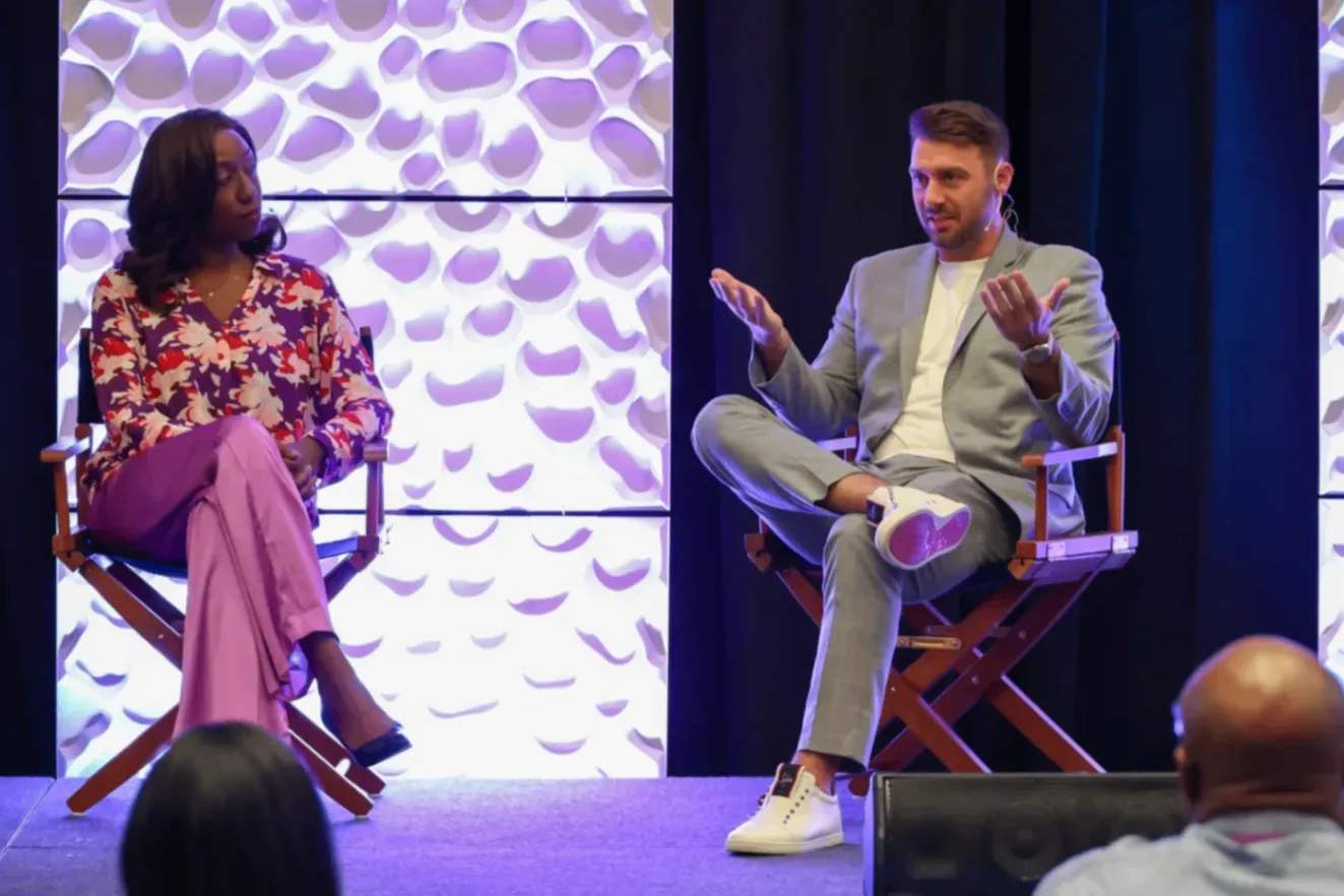 Rachel Bolton and another panelist in conversation on a lit stage